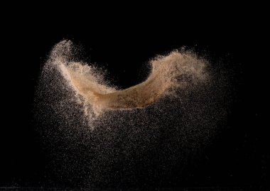 Doğal kum patlaması, parçacık nokta tahıl dalgası. Soyut bulut sineği. Kahverengi kum sıçraması hava veriyor. Siyah arkaplan izole edildi