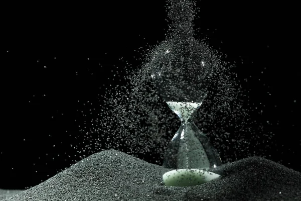沙漏在黑色背景之上的白色沙上增加了更多的时间沙粒 白沙漏显示更多的时间截止日期延长时间管理希望概念小时玻璃 生命时钟经过 — 图库照片
