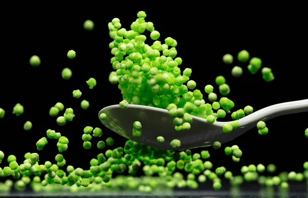Sago seeds flying explosion, green grain wave floating. Abstract cloud fly splash in air. Green colored Sago seeds is material food. Black background Isolated selective focus blur