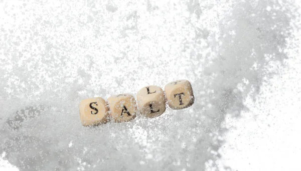 塩アルファベット文字ビーズ結晶ナトリウムで飛ぶ 味付け食品を減らすために少ない塩味の概念 医療の概念についての塩の手紙の単語 隔離された白い背景 — ストック写真