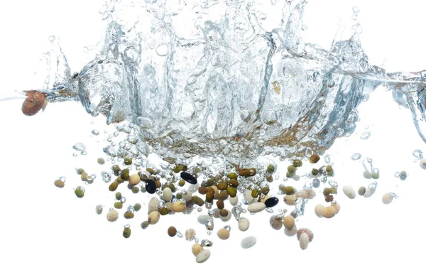 Бобы Мульти Зерна Падает Воду Создает Пузырьки Воздуха Поверхности Красно — стоковое фото