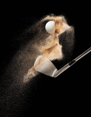 Kum sığınağından golf topu tişörtü patladı. Golfçü topa sopayla vurdu, kumdan yeşile. Golf sopası, kum deposu patlamasında topa vurdu. Siyah arkaplan izole edilmiş dondurucu hareket