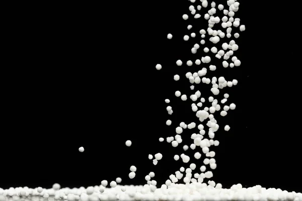 メジャーカップから落下するサゴの種子 白い粒波が浮遊し アブストラクトは空気中で飛び散る 白サゴの種子は材料食品です 黒の背景選択的焦点ぼかし — ストック写真