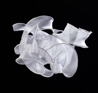 Beyaz kurdele havada düz uçuyor ve kıvrımları parlak. Süslemek için hediye olarak beyaz kar kurdelesi, kıvrımlı kıvrımlı uzun kıvrımlı doğum günü partisi. Siyah arkaplan izole