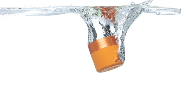 Контейнер Orange Cosmetic Падает Прозрачную Воду Воздушным Пузырем Косметическая Обработка — стоковое фото