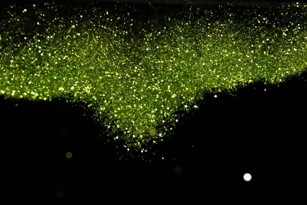 Explosion metallic green glitter sparkle. Green Glitter powder spark blink celebrate, blur foil explode in air, fly throw green glitters particle. Black background isolated, selective focus Blur bokeh