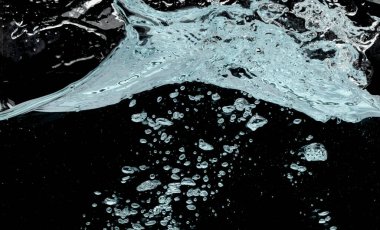 Temiz bardağa dökülen su. Dökülen temiz sudan dolayı içeride kabarcıklar var. Soda içmek, sifonu çekmek, hava kabarcığı. Siyah arkaplan izole edilmiş dondurucu element