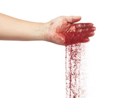 Kırmızı metalik parıltı elinden düşüyor. Kırmızı parıltılı kum kıvılcımı Çin 'in yeni yılını kutluyor, parçacıklar elden dökülüyor. Beyaz arkaplan izole, seçici odak Görüntü bokeh