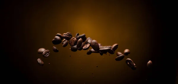 Coffee roasted bean ground fly explosion, Coffee crushed ground float pouring mix with beans. Roasted Coffee bean powder ground dust splash explosion in mid Air. Black background Isolated gold bokeh