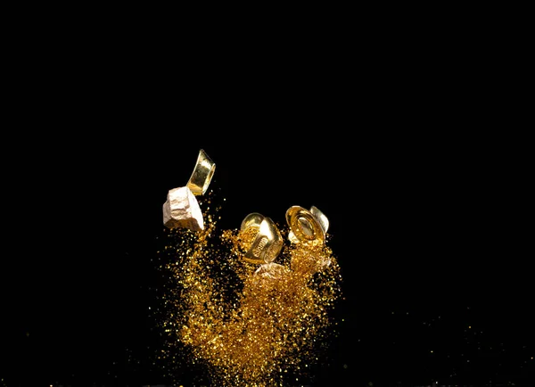 ゴールドインゴットチャイナマネーバートークンは 空気中のほこりの粒子で飛ぶ 中国の黄金の砂粒に浮かぶ黄金の金のゴールドのインゴット 言語は豊かな繁栄である 隔離された黒い背景 — ストック写真