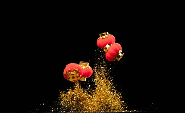 Gold Chinese Money lantern fly with dust particle in air. Chinese new year Yuanbao gold lantern floating to golden money sand particle. Language is wealthy prosperity. Black background isolated