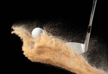 Kum sığınağından golf topu tişörtü patladı. Golfçü topa sopayla vurdu, kumdan yeşile. Golf sopası, kum deposu patlamasında topa vurdu. Siyah arkaplan izole edilmiş dondurucu hareket