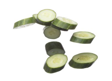 Cucumber fly fall, green fresh vegetable cucumber cut chop slice. Organic fresh vegetable with eaten leaf of long cucumber, close up texture. White background isolated freeze motion high speed shutter