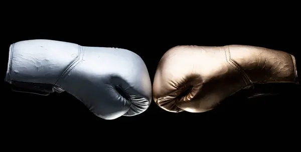シルバーとゴールドの2つのボクシンググローブは スポーツの対決に直面し 一緒にヒット 隔離された黒い背景 — ストック写真