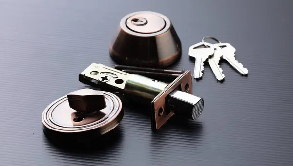 Small parts of Deadbolt lock to protect security safety on door window house. Incomplete many parts of deadbolt lock before assemble to door window with key over black background