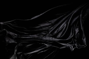 Siyah kadife kumaşın kıvrımlı uçtuğunu hissetti. Tekstil siyah kadife parçası kumaşın havaya düştüğünü hissetti. Siyah arkaplan izole, koyu gölgeleme ortamı