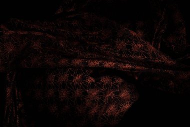 Bakır kırmızı dantel kumaş kıvrımlı uçuyor, tekstil bakır dantel kumaş parçası havaya düşüyor. Siyah arkaplan izole, koyu gölgeleme ortamı