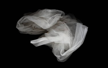 Eğri şeklinde uçan beyaz organza dantel kumaş, beyaz organza dantel kumaş parçası havaya düştü. Siyah arkaplan izole, koyu gölgeleme ortamı