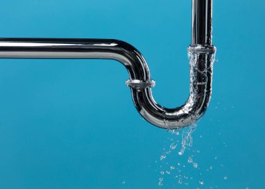 Lavabonun altındaki krom paslanmaz çelik borudan su sızdırıyor. Banyodaki borulardan su sızıyor ve su tıkanmış. Mavi banyo arka planı izole edildi