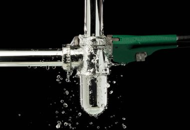 Ağır Görevli Anahtarı lavabonun altındaki su sızıntısını tamir ediyor. Banyodaki boru hortumundan sızan lavabo su sızdırıyor ve su damlası gibi ingiliz anahtarıyla tamir ediliyor. Siyah arkaplan izole