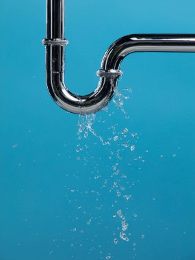 Lavabonun altındaki krom paslanmaz çelik borudan su sızdırıyor. Banyodaki borulardan su sızıyor ve su tıkanmış. Mavi banyo arka planı izole edildi