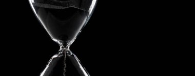 Close up of white Sand Hourglass over black background. Sand through time hourglass fall down as time management concept clipart