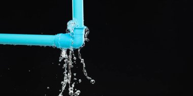 Lavabonun altındaki mavi plastik borudan su sızdırıyor. Mavi PVC plastik borudan sızan su banyodaki su tesisatını bozdu. Siyah arkaplan izole
