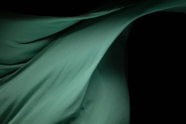 Green Organza fabric flying in curve shape, Piece of textile Green Organza fabric throw fall in air. Black background isolated, dark shading environment clipart