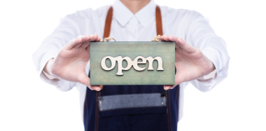 Owner person hold Open Sign Business to show service at door entrance store, cafe, retail and welcome shop. Happy Entrepreneur female wear waitress dress as open business time again concept