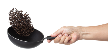 Black Pepper seeds fly throw up in pan, Black Pepper float explode, abstract cloud fly. Black Peppercorn splash throwing in Air. White background Isolated high speed shutter, freeze motion