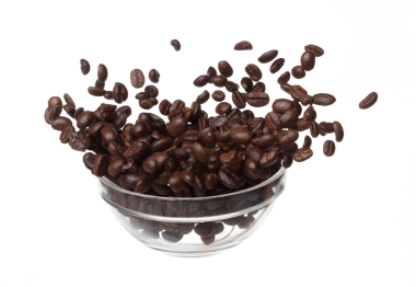 Coffee bean fall down pour in glass bowl, Coffee seeds float explode, abstract cloud fly. Coffee beans splash throwing in Air. White background Isolated high speed shutter, freeze motion
