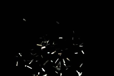 Birçok Parti simleri birçok grupta dağılır. Gümüş Konfeti folyosu yere düşüyor. Gümüş Konfeti Foil patlaması, soyut bulut sineği. Siyah arkaplan izole ögesi dondur