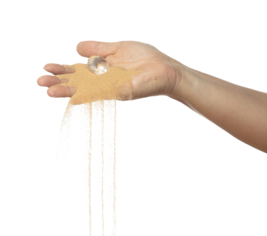 Elde uçuşan elmas kristal sineği. Elmas değerli taş patlaması kuru güneşin altında kum tozu ile uçuyor. Beyaz arkaplan yüksek hız deklanşör dondurma hareketini izole etti