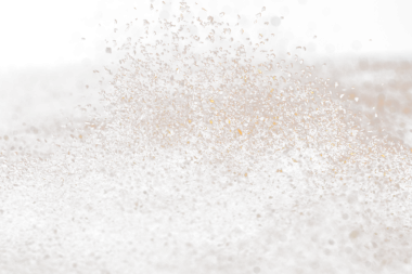 Ground Coffee roasted powder dust fly explosion, Coffee crushed ground float pouring. Roasted Coffee powder ground dust splash explosion in mid Air. Black background Isolated selective focus blur