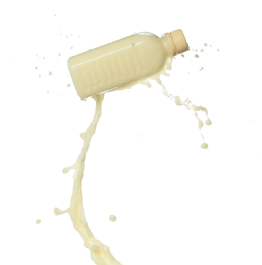 Soya fasulyesi sütü şişenin içine dökülüyor. Soya sütü ya da kozmetik krem nemlendirici boya renginde sıçrar. Beyaz arkaplan yüksek hız deklanşör dondurma hareketini izole etti