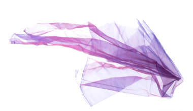 Mor Violet Organza kumaşı kıvrımlı uçuyor. Tekstil mavisi gökyüzü kumaşı parçası havaya uçuyor. Beyaz arkaplan izole hareket bulanıklığı