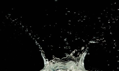 Crown sudan nesneye dalgalı hareketle kavisli düşüş patlaması yapıyor. Siyah arka plan izole. Crown Water damlacıklar ve dalgalar halinde çırpınan şekil yaratmak için nesnenin üzerine su sıçrar.. 