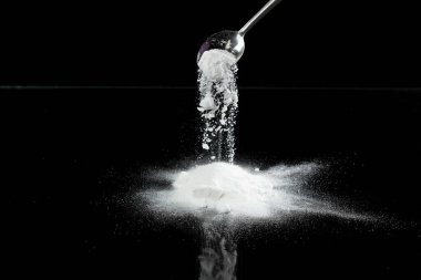 Tapyoka nişasta un sineği patlaması, beyaz pudra tapyoka nişastası havaya düştü. Baharat un tozu element malzemesidir. Göz farı aşkıydı. Siyah arkaplan izole seçili odak bulanıklığı