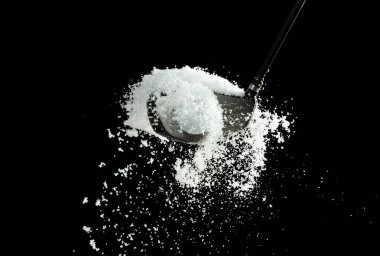 Golf Ball golfer hit snow to explode and splatter. Sand wedge golf dick ball from snow field and snow fly in air. Night black background isolated