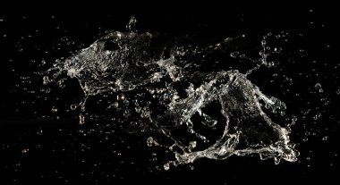 Crown sudan nesneye dalgalı hareketle kavisli düşüş patlaması yapıyor. Siyah arka plan izole. Crown Water damlacıklar ve dalgalar halinde çırpınan şekil yaratmak için nesnenin üzerine su sıçrar.. 