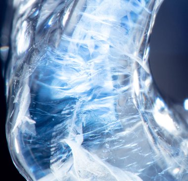 Makro yakın plan altında, buz soyut desenleri ve soğuk arka plan dokularını ortaya çıkarır. Buz kırılan kristal oluşumlar, buz ve sudan doğar, şeffaf ve güzel bir tasarım yaratır.