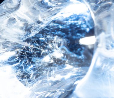 Makro yakın plan altında, buz soyut desenleri ve soğuk arka plan dokularını ortaya çıkarır. Buz kırılan kristal oluşumlar, buz ve sudan doğar, şeffaf ve güzel bir tasarım yaratır.