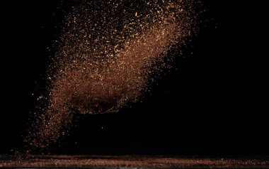 Kavrulmuş kahve tozu toz bulutu havaya sıçradı. Yer kahvesi kavrulmuş toz tozu sineği patlaması, ezilmiş kahve şamandırası dökülmesi. Siyah arkaplan izole edildi