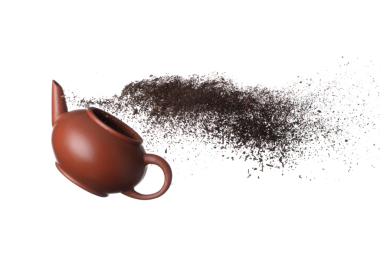 Black dried leave Tea fly on pot. Small Fine size tea leaf flying explosion, Abstract cloud fly. Brown colored Teas splash throwing in Air with tea pot. White background Isolated high speed freeze