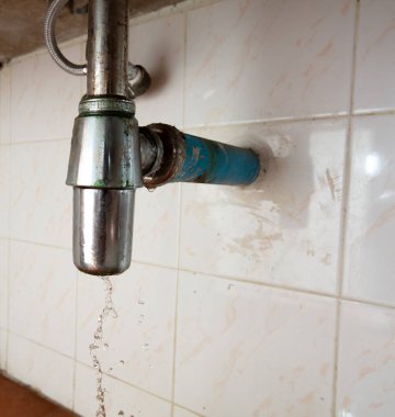 Lavabonun altındaki su borusunda sızıntı var, kanalizasyon tıkanmış. Su borunun etrafında sızıyor çünkü lavabo yavaş yavaş boşalıyor ve evde su sıçrıyor, yüksek hızlı deklanşör dondurucu hareketli fotoğraf.