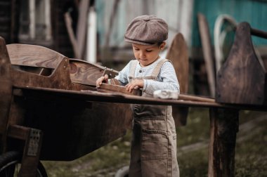 Doğal bir ortamda, el yapımı bir uçakta genç bir havacı elinde bir makina ile kanadı onarıyor. Filmin otantik havası. Eski