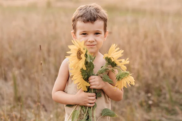 Roztomilý Malý Rozesmátý Chlapec Poli Slunečnic Držící Rukou Obrovskou Kytici — Stock fotografie