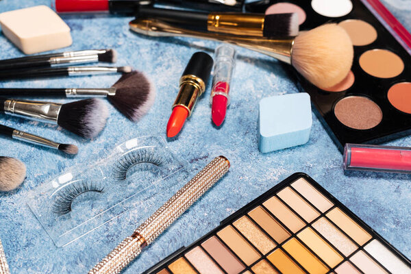 set decorative cosmetics, makeup brushes blue background. view from top