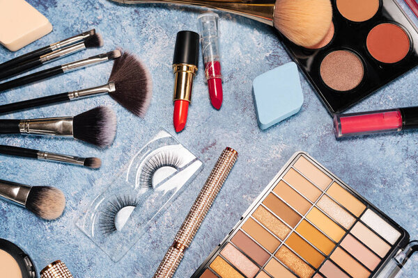 set decorative cosmetics, makeup brushes blue background. view from top