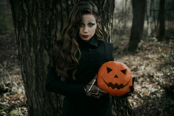 彼女の手のカボチャに囲まれた魔女のゴシック悲観的なイメージの若い女性 ハロウィンコスチューム — ストック写真